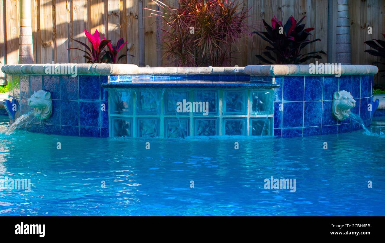 Ein Pool in einem tropischen Reiseziel mit Lion Head Fountains Wasser Ausspucken Stockfoto