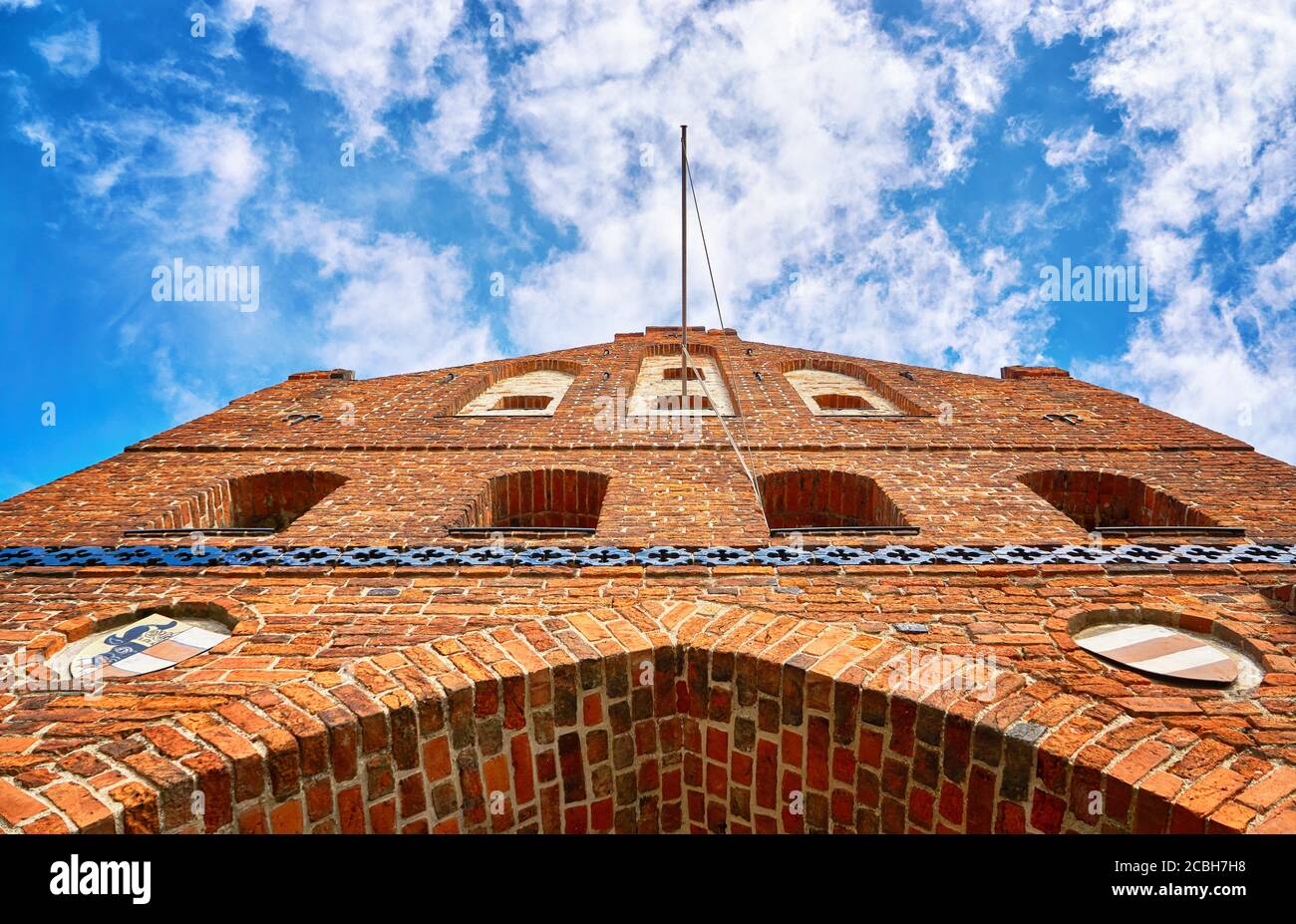 Historisches Backsteinstadttor unter blauem Himmel mit Wolken in der Hansestadt Wismar an der Ostsee. Stockfoto