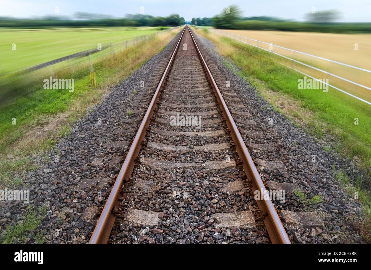 Verkleinerende Perspektive auf einer Eisenbahnstrecke mit hoher Geschwindigkeit Bewegungsunschärfe Stockfoto
