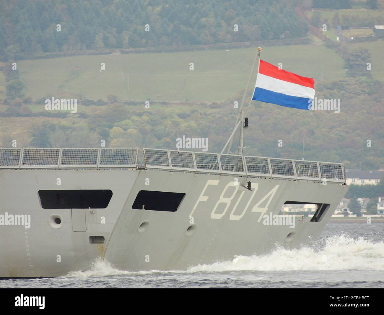 Die Royal Netherlands Navy Ensign fliegt vom Heck der HNLMS De Ruyter (F804), während das Schiff Greenock am Start von Joint Warrior 12 passiert. Stockfoto