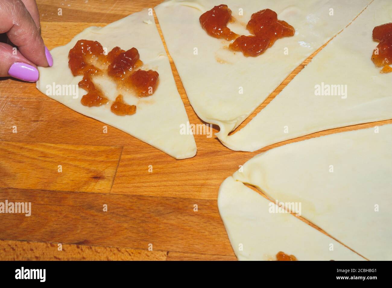 Rohe Teigscheiben mit Marmelade für Croissant Backen. Teig kochen Prozess Stockfoto