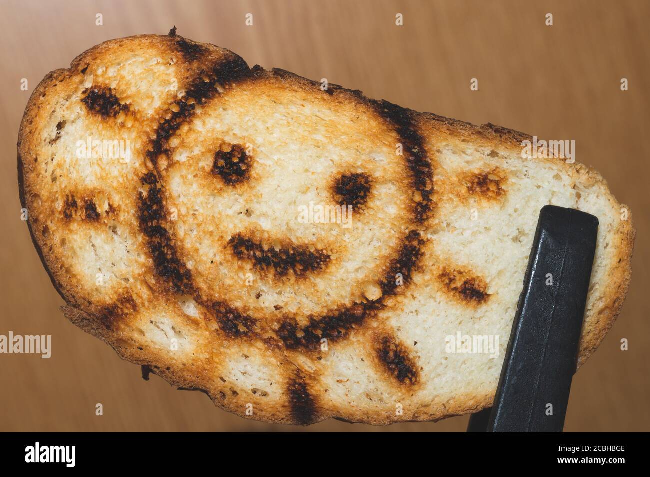 Geröstetes Brot mit lächelndem Sonnenbild. Symbol auf dem Toast Stockfoto