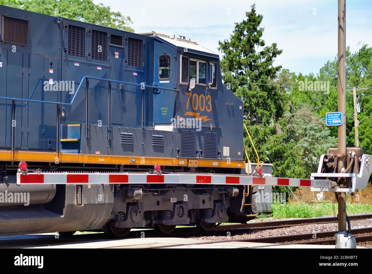 Watseka, Illinois, USA. Eine Lokomotive führt einen CSX Transportation Manifest Güterzug durch einen Bahnübergang. Stockfoto