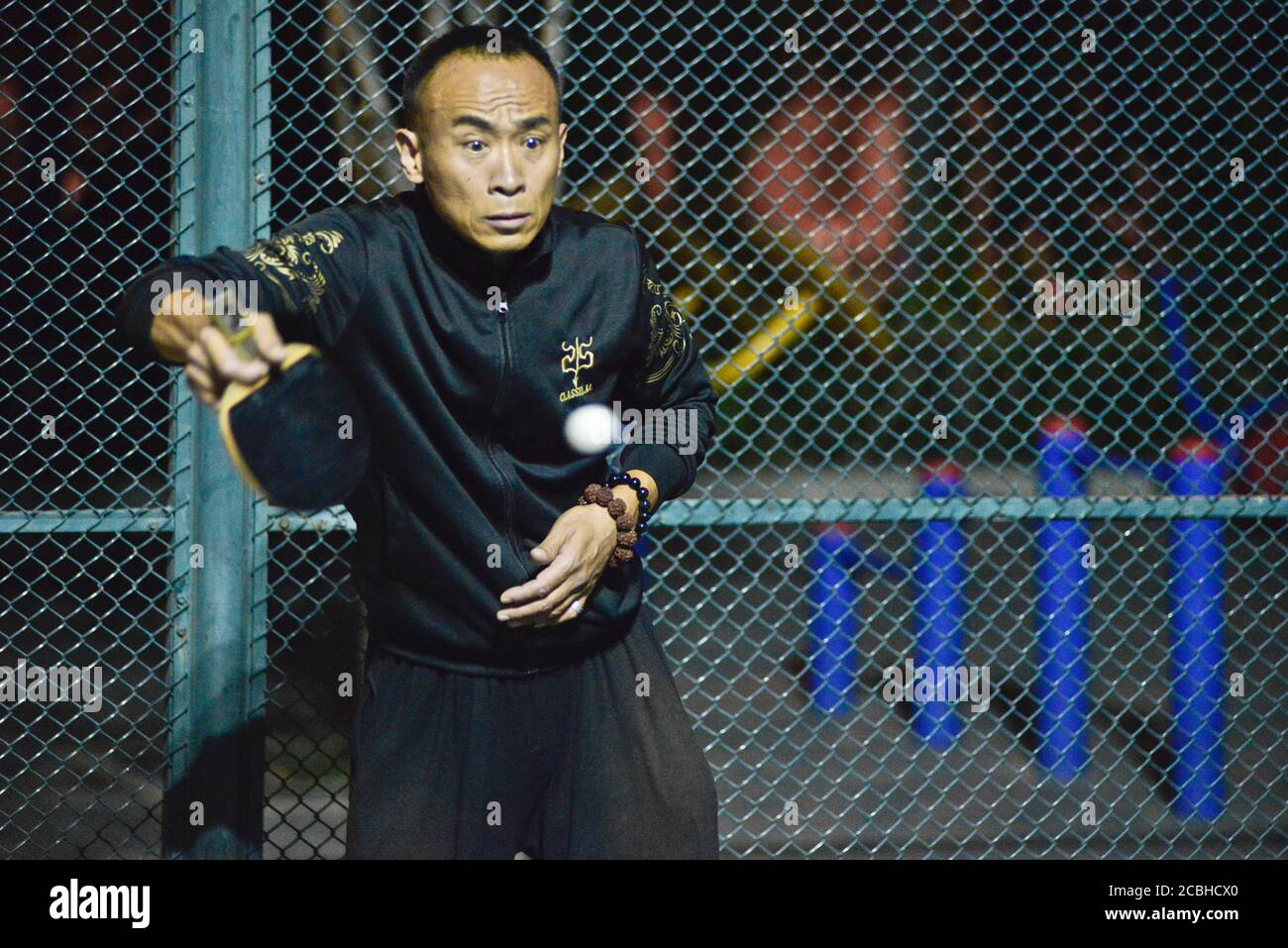 Chinesischer Mann spielt Tischtennis in einem öffentlichen Park, Peking, China Stockfoto