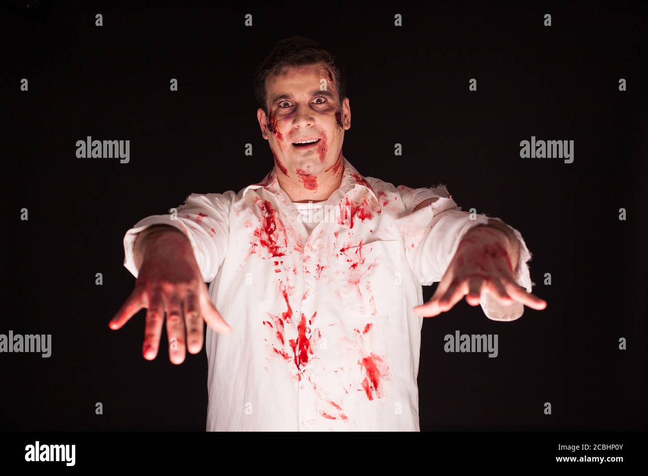 Scary Mann mit blutigen Händen über schwarzem Hintergrund. Der Mensch verbreitet Terror. Stockfoto