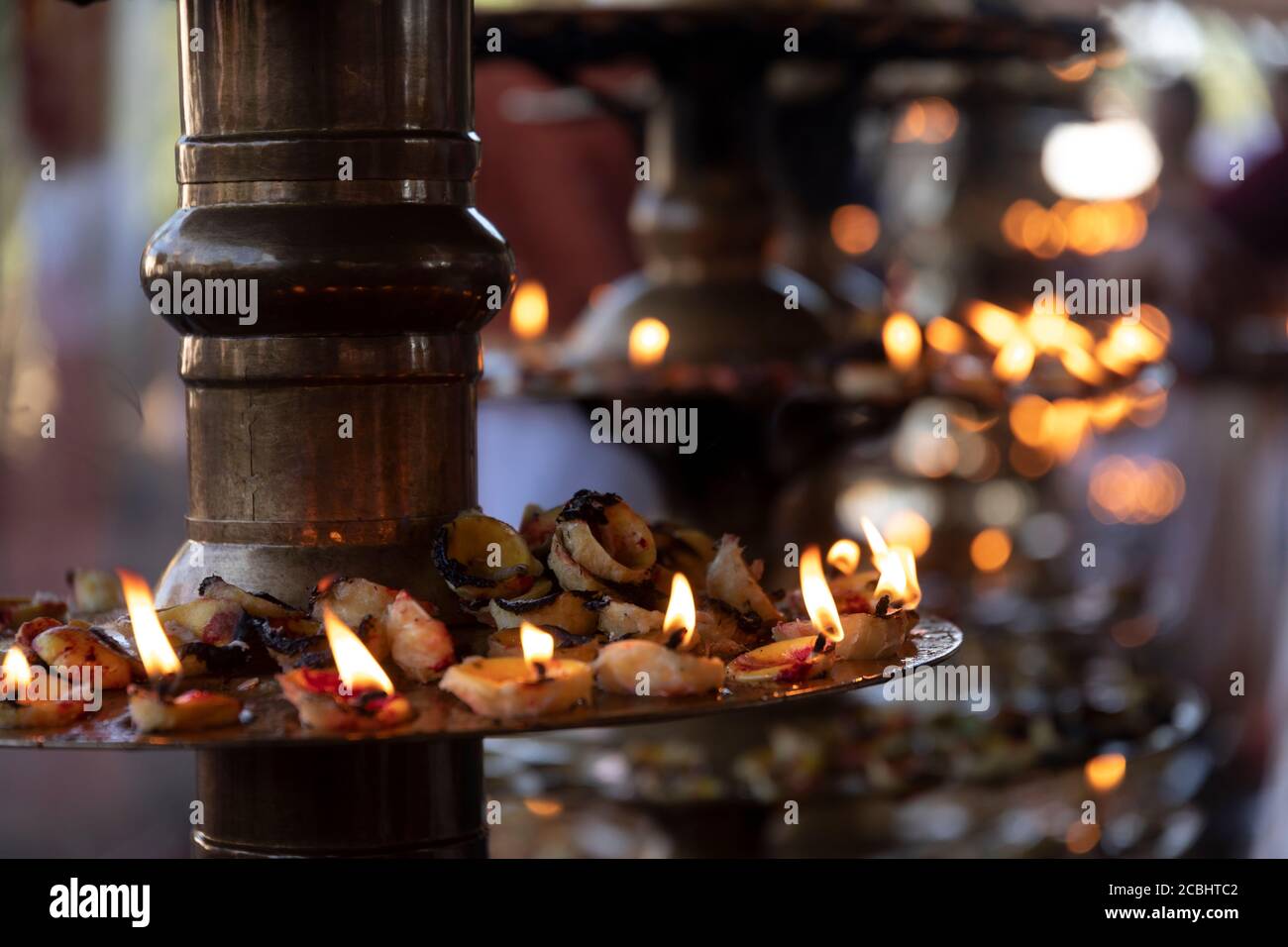 Eifrige Anhänger, die Zitronenlampen als hinduistisches Ritual anzünden Stockfoto