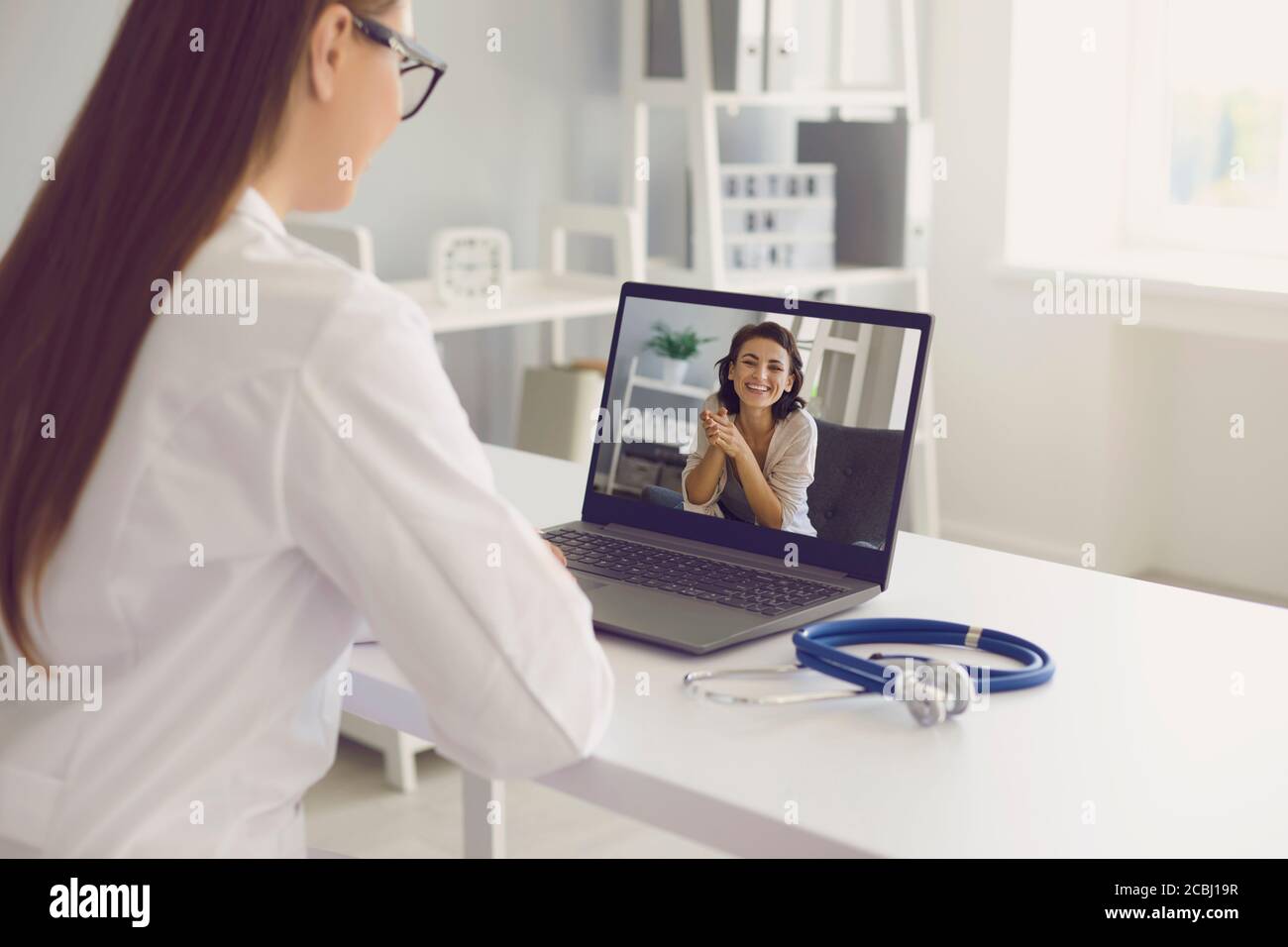 Videoanruf zum Arzt online. Das Mädchen Patient sagt, die Symptome der Krankheit Pandemie hat eine Videokonferenz Laptop-Computer zu Hause. Stockfoto