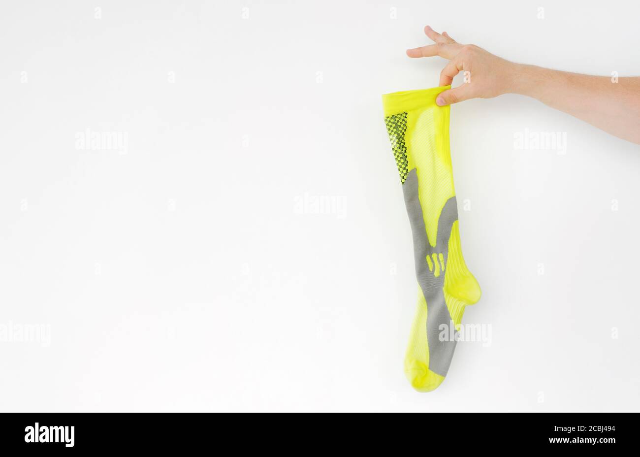 Stinkende gelbe Laufsocke in der Hand auf hellem Hintergrund Stockfoto