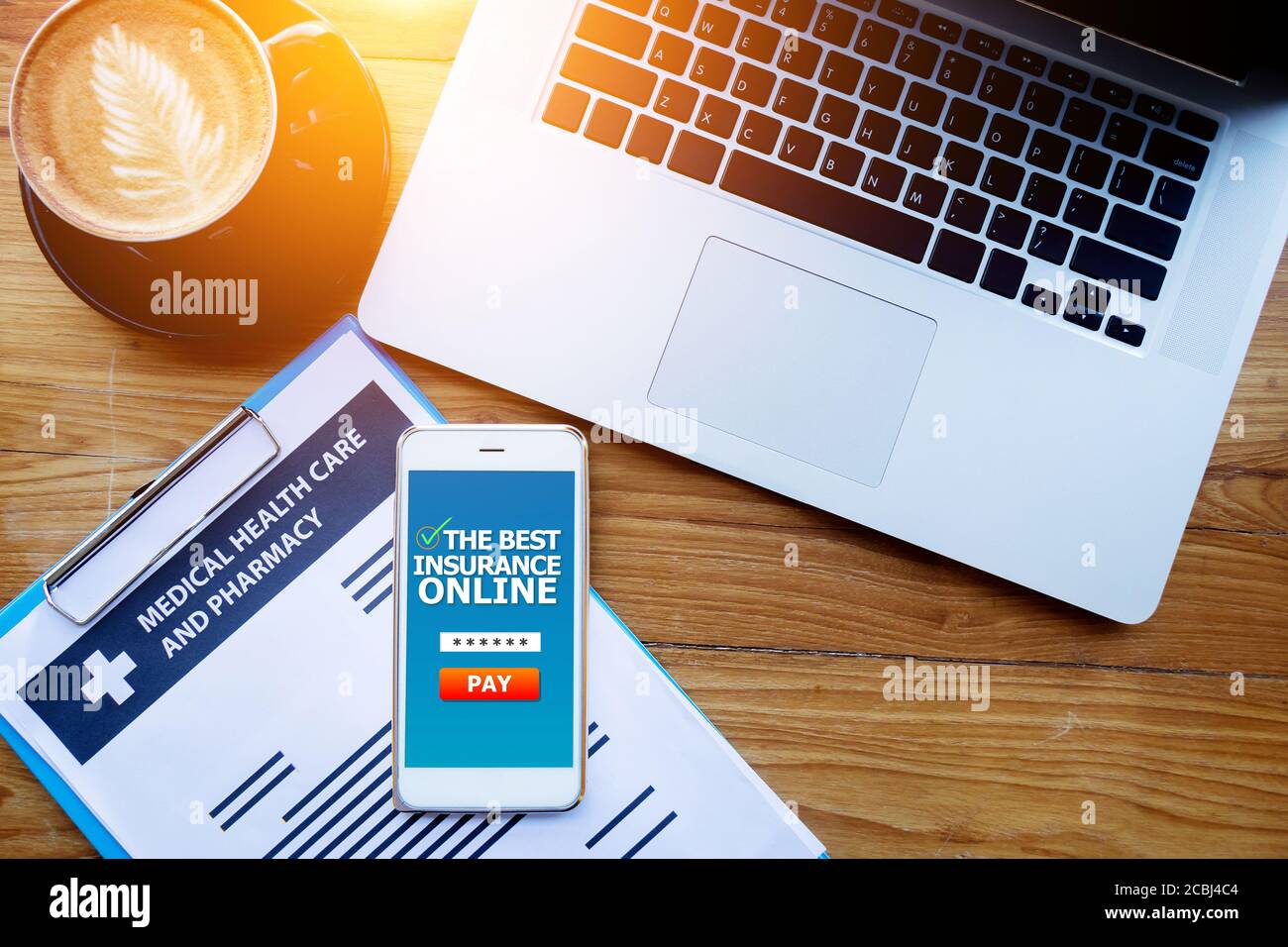 Medizinische Krankenversicherung Online-Konzept. Medizinische Krankenversicherung Dokument auf Zwischenablage mit Laptop und Versicherung Online-Bildschirm auf Handy Stockfoto