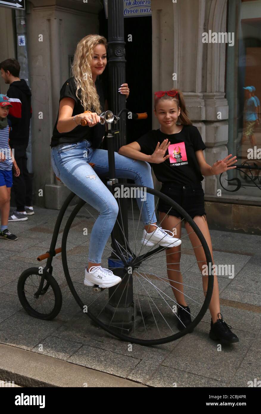 Krakau. Krakau. Polen. Frau und Mädchen posig auf Penny-Farthing Fahrrad. Stockfoto