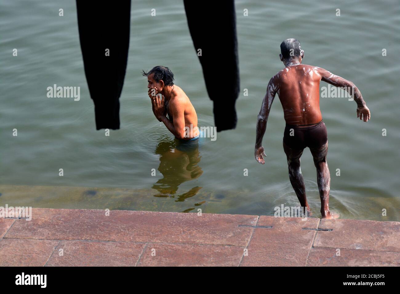 Zwei nicht identifizierte Erwachsene Männer Baden am ganges Fluss in der Nähe von assi Ghat in varanasi uttar pradesh indien. Stockfoto