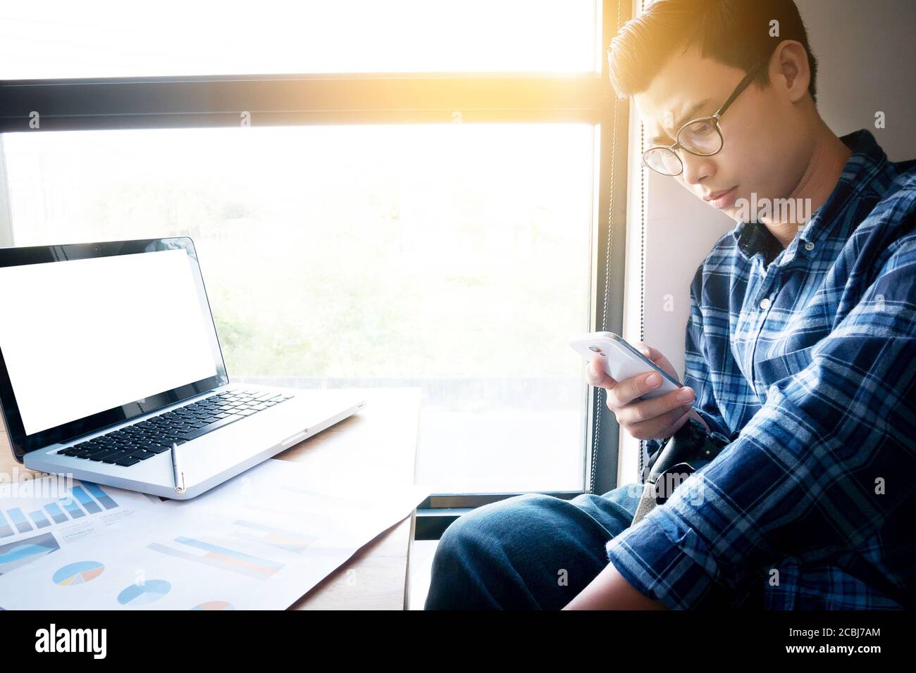 Business Buchhaltung Menschen, sparen, Finanzen, Wirtschaft Konzept. Serious asiatischen Geschäftsmann mit Smartphone mit Papierkram, Dokumente für die Statistik Stockfoto