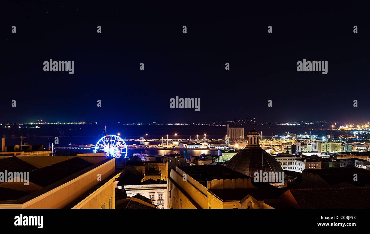 Draufsicht auf eine kleine italienische Stadt (cagliari) mit Stadt Lichter und ein Riesenrad Stockfoto