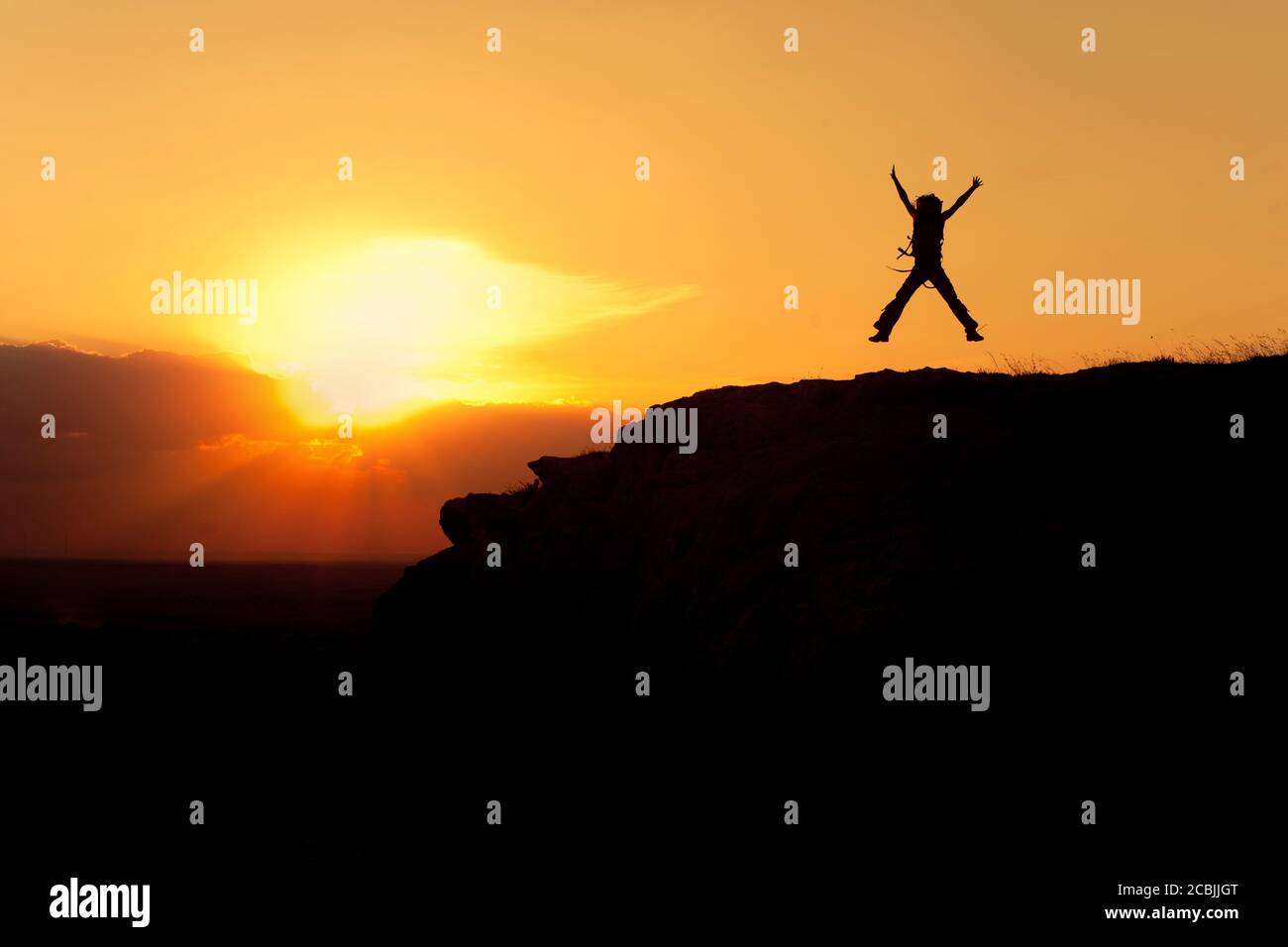 Silhouette der springenden Frau mit Rucksack Stockfoto