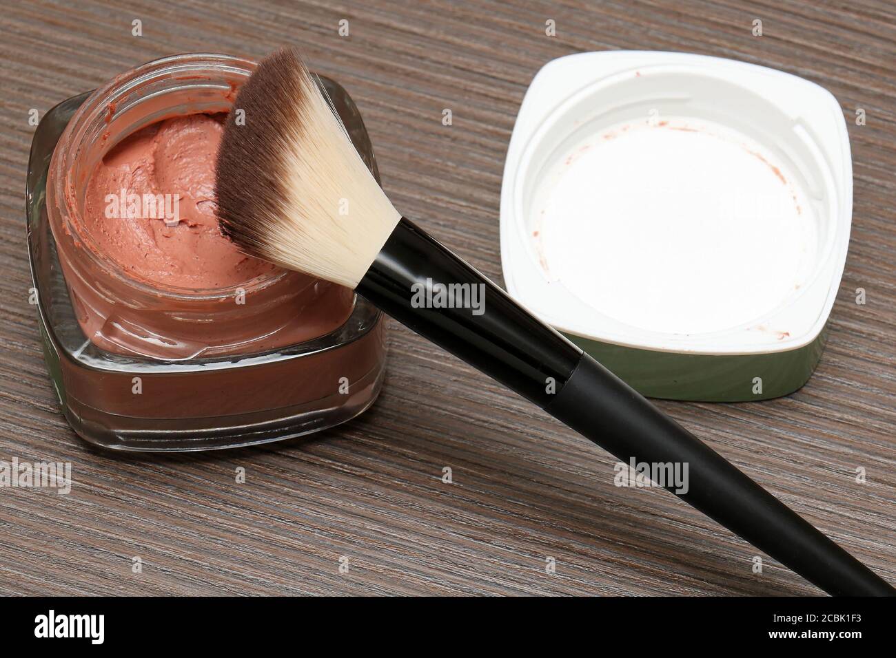 Red Clay Mask in Glas Glas auf Holz- Hintergrund Stockfoto