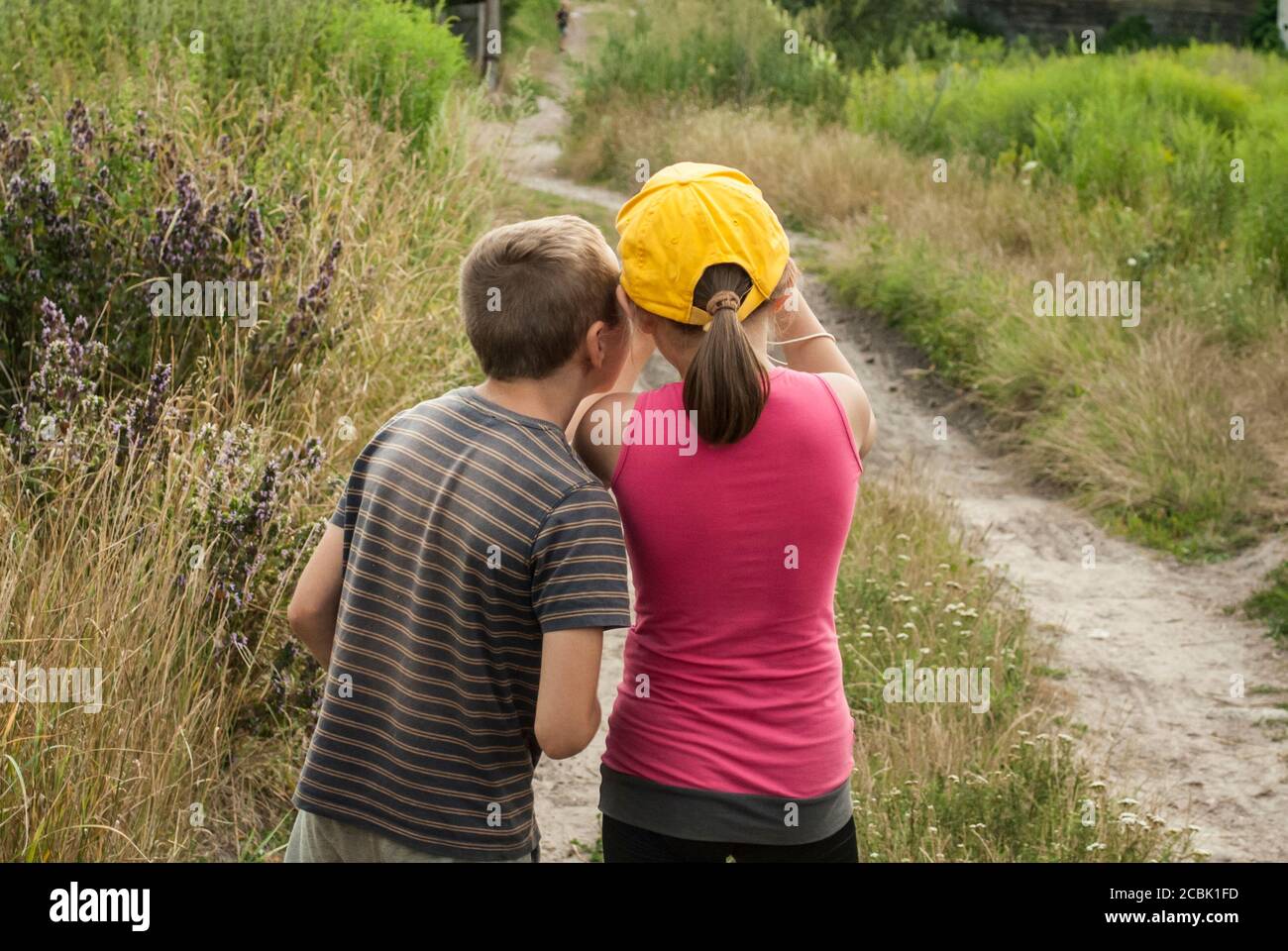 Zwei 10-jährige Kinder schauen sich etwas an. Blick von hinten Stockfoto