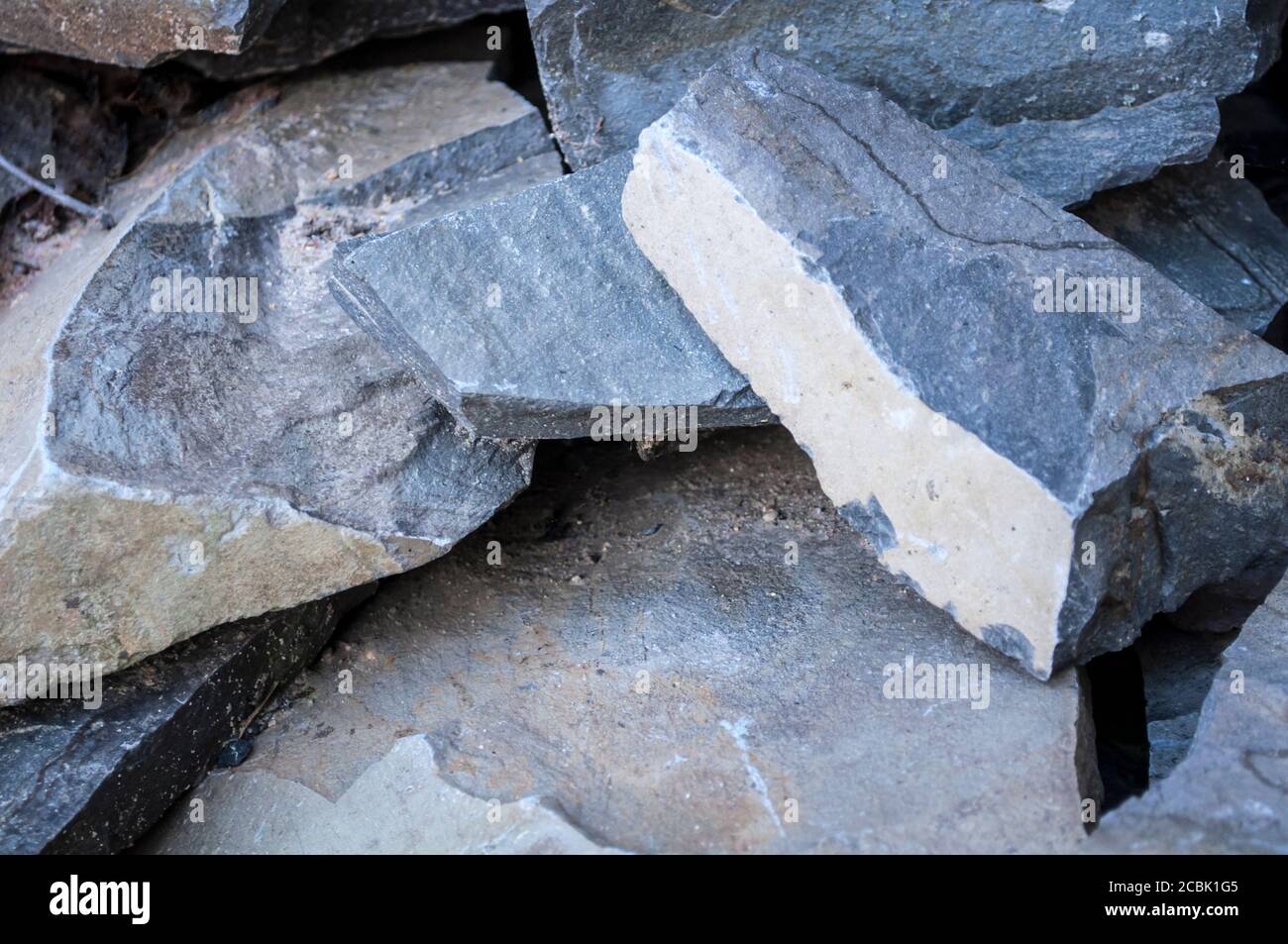 Stapel von großen Steinen, Vorbereitung für den Bau. Großer grauer Block, Steinhintergrund Stockfoto