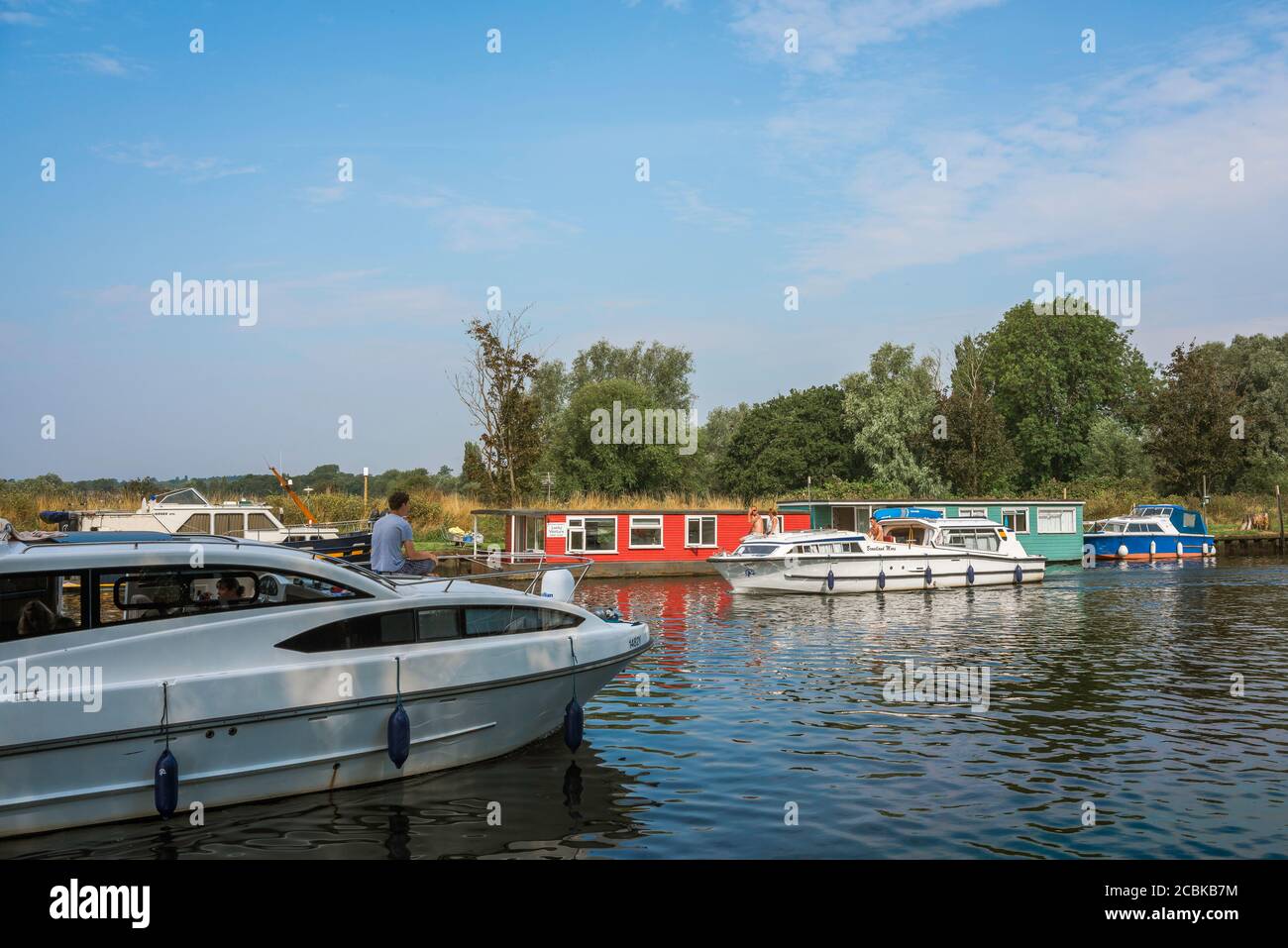 Segelurlaub, Blick im Sommer von Menschen segeln Vergnügungsboote entlang des Flusses Waveney an der Norfolk Suffolk Grenze in East Anglia, England, Großbritannien Stockfoto