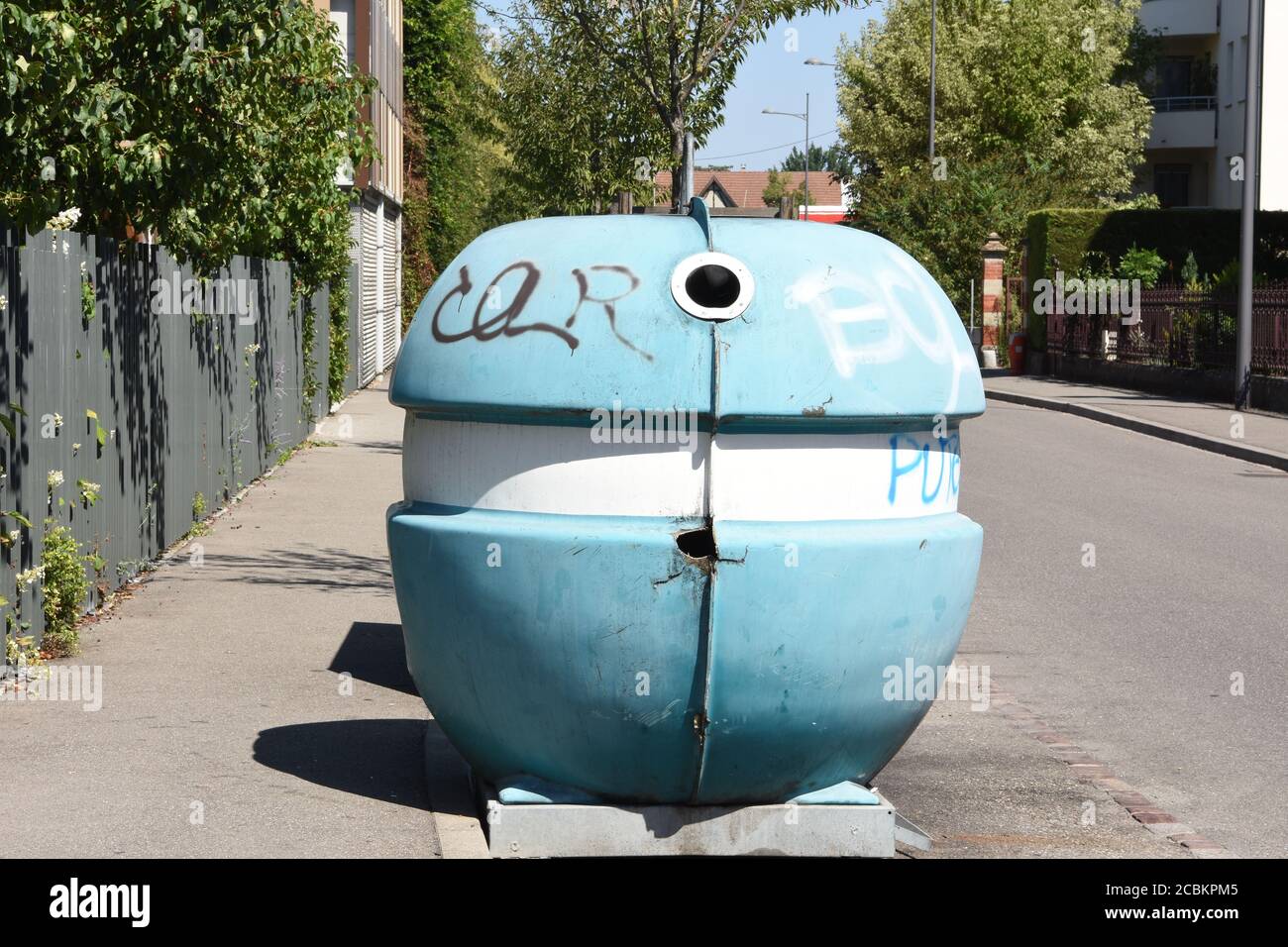 Blauer Müllrecycling-Behälter in Kugelform für Glasabfälle draußen in der leeren Straße vor den Wohnhäusern in Colmar, Frankreich. Stockfoto