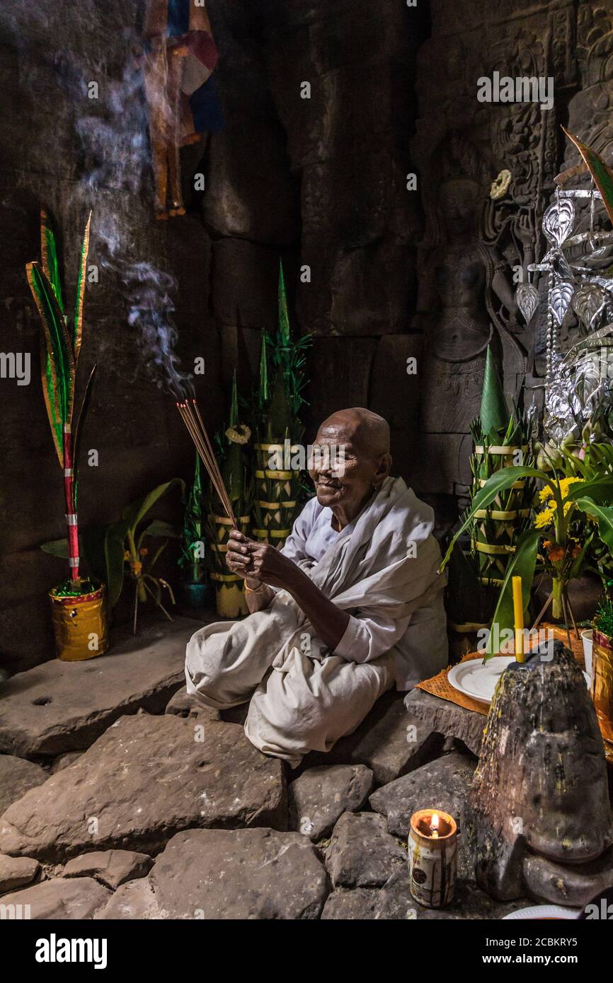 Eifrige Nonne, zündet Weihrauch an und bietet Gebete im Preah Khan Tempel, Angkor, Kambodscha an Stockfoto