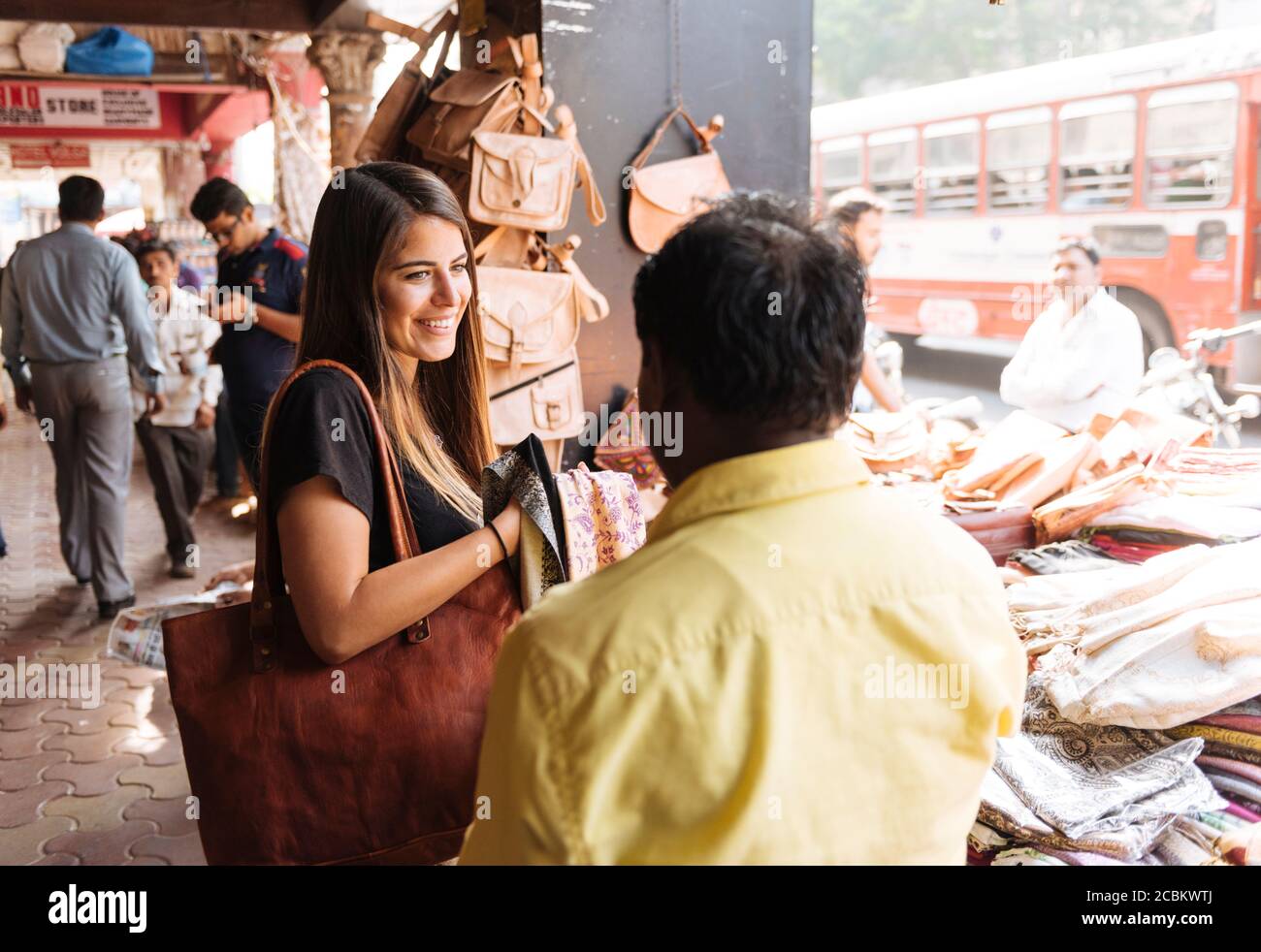 Junge weibliche Touristin am Textilmarkt Stand, Mumbai, Indien Stockfoto