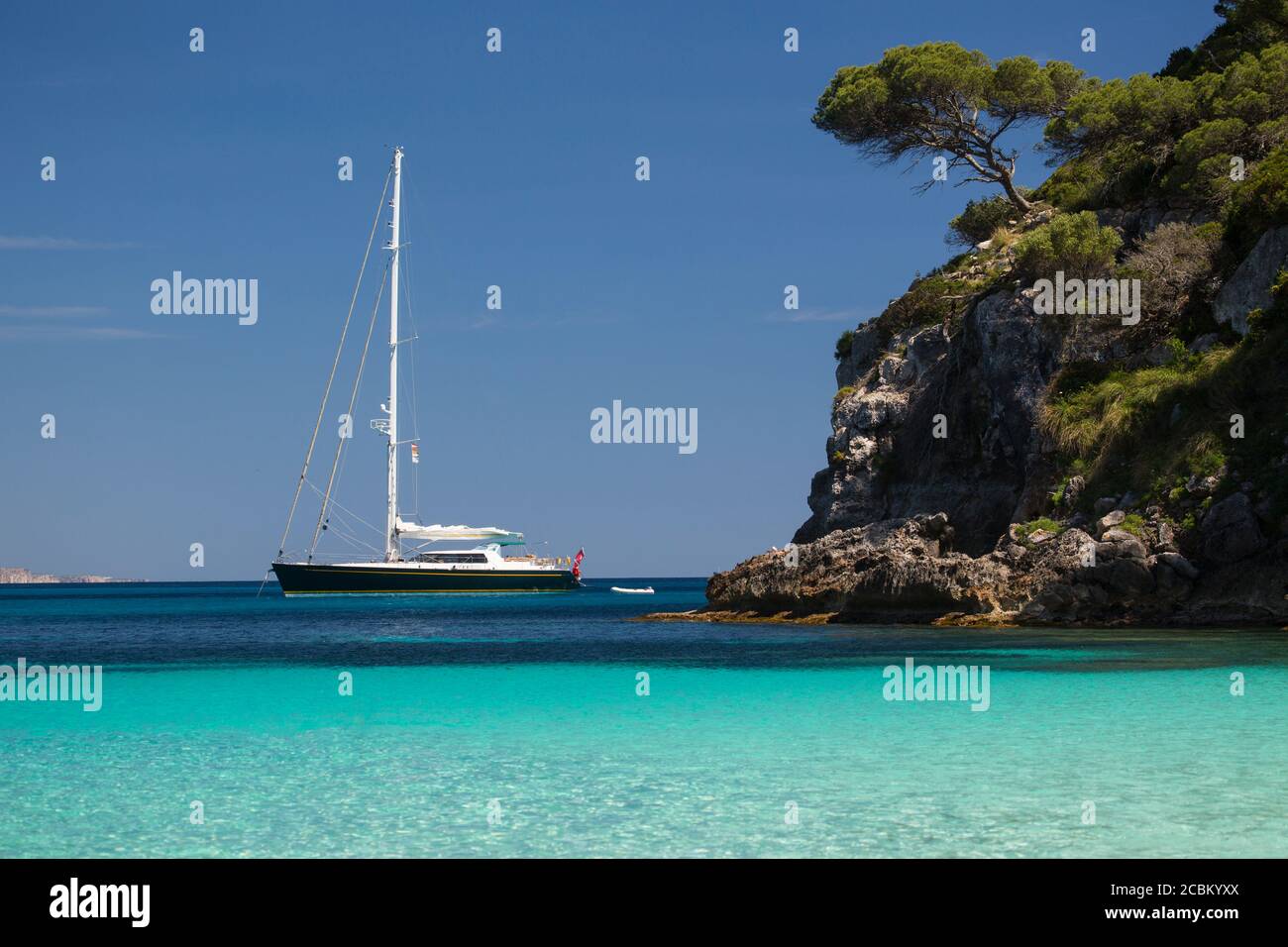 Küstenansicht mit Yacht am Horizont, Cala Macarelleta, Menorca, Spanien Stockfoto