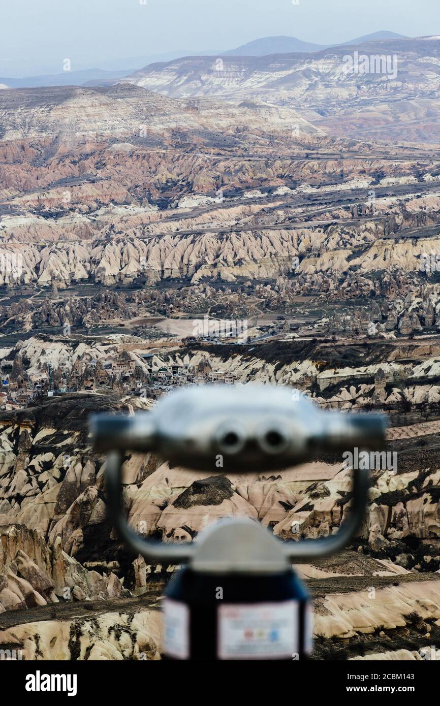 Münzfernglas vor zerklüfteter Felsformation, Uchisar, Kappadokien, Türkei Stockfoto