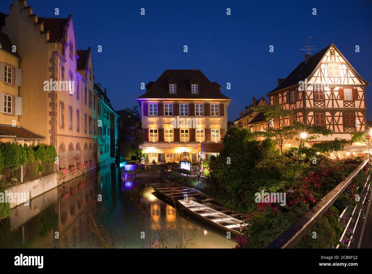 Boote auf Kanal bei Nacht, umgeben von mittelalterlichen Häusern, Colmar, Elsass, Frankreich. Elsässische Weinstraße Stockfoto