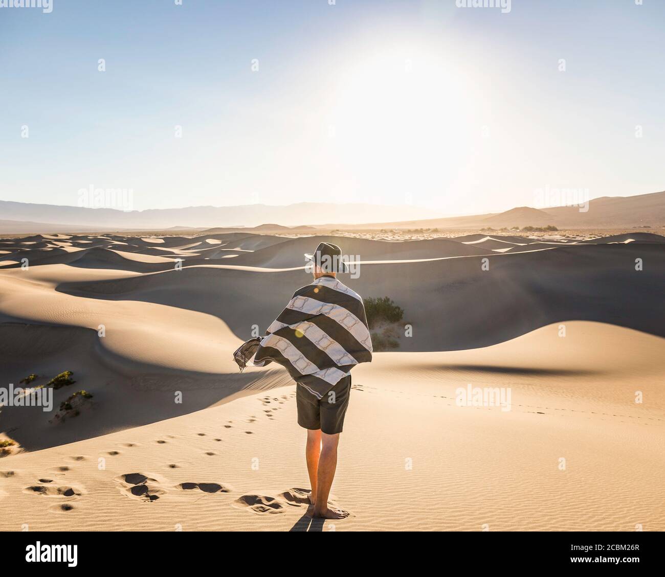 Mann mit Handtuch und Hut, Mesquite Flat Sand Dunes, Death Valley National Park, Furnace Creek, Kalifornien, USA Stockfoto