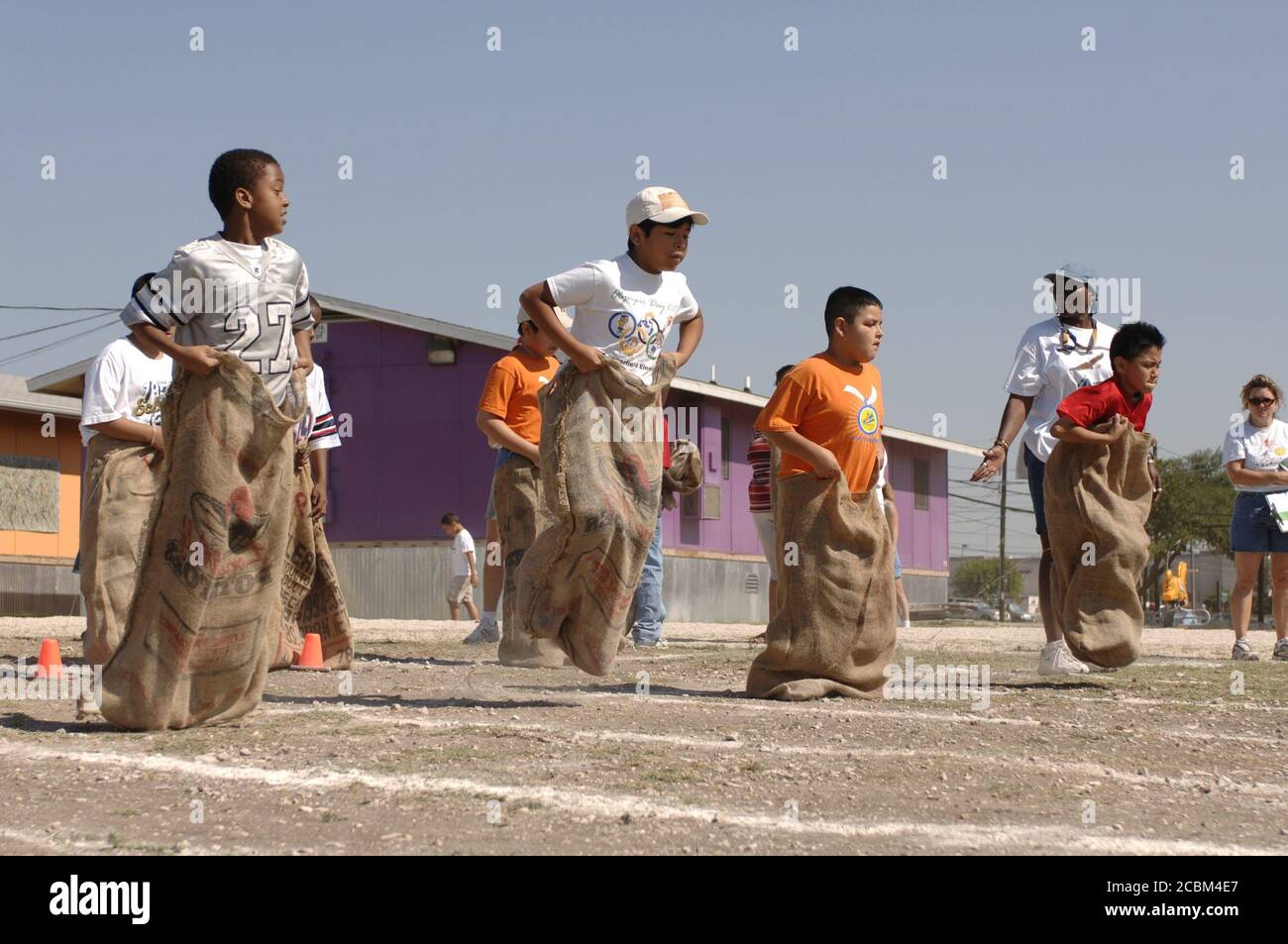 Austin, Texas, USA, Mai 2006. Die Jungen der vierten Klasse nehmen am 40-Yard-Sack-Rennen am „Track & Field Day“ der Grundschule im Raum Austin Teil, der traditionell das Frühjahrssemester an vielen öffentlichen Grundschulen in der Umgebung beendet. ©Bob Daemmrich Stockfoto