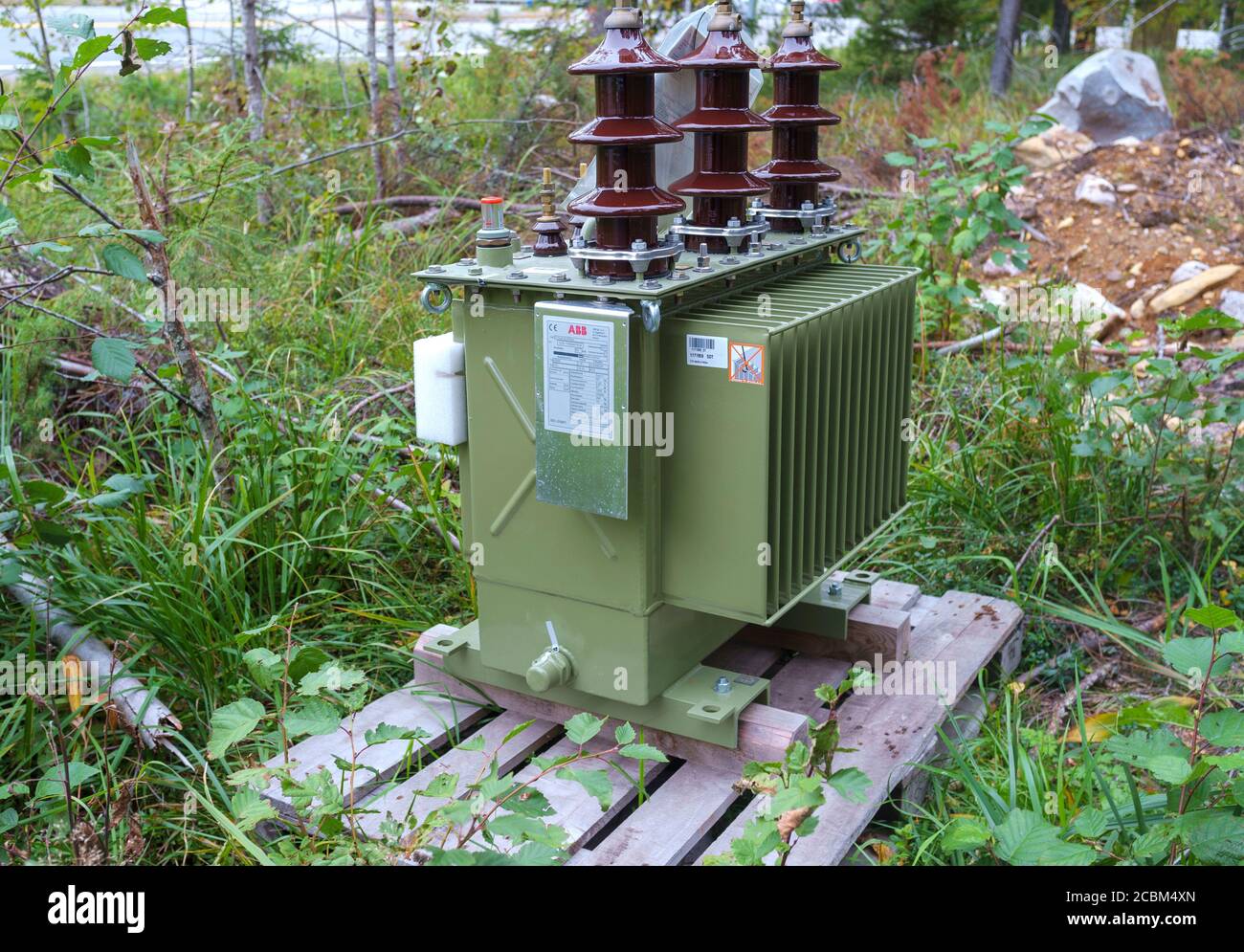Neuer Transformator für das Stromnetz geliefert und auf dem Boden liegend , warten auf die Installation an Stromleitungen , Finnland Stockfoto