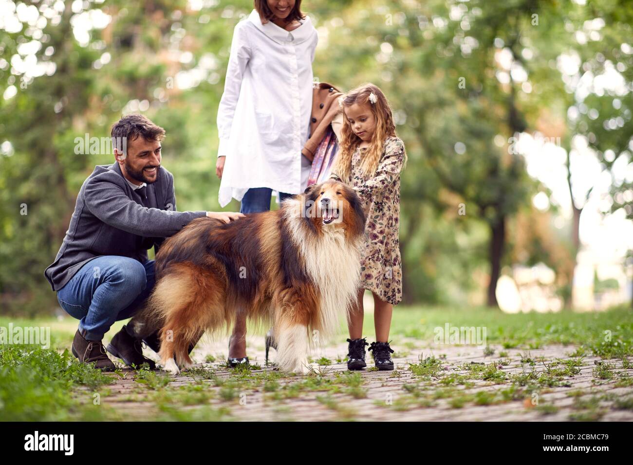 Familie verbringen gemeinsam Freizeit in einem Park mit shetland Schäferhund Stockfoto