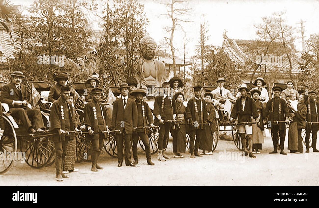 Nagasaki , Japan 1911 - Europäische und amerikanische Touristen stehen vor einer Rikscha-Fahrt für ein Foto an (31 Jahre vor der Zerstörung der Stadt durch eine Atombombe am 9. August 1945). Obwohl es sich um französische Fahrzeuge handelt, wurde diese Fahrzeugform in Japan nach Aufhebung des Verbots von Radfahrzeugen aus der feudalen Tokugawa-Shogunat-Zeit (1603–1868) angenommen. Stockfoto