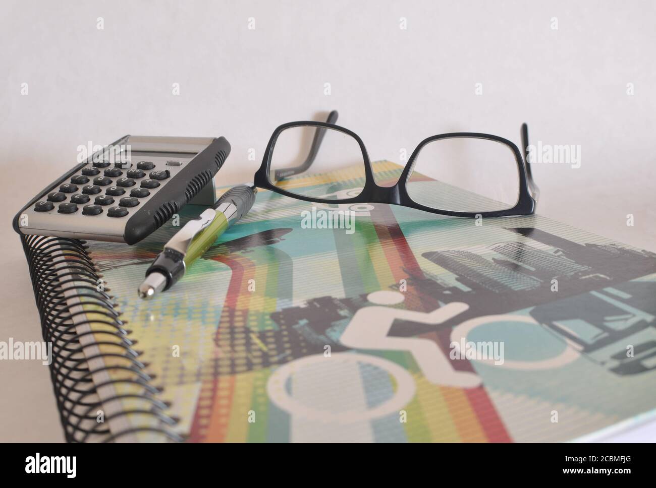 Schreibheft mit farbigem Cover, Brille, Stift und nicht-digitalem Rechner auf weißem Hintergrund, Konzeptfoto, zurück zur Schule, Brasilien, Südamerika Stockfoto