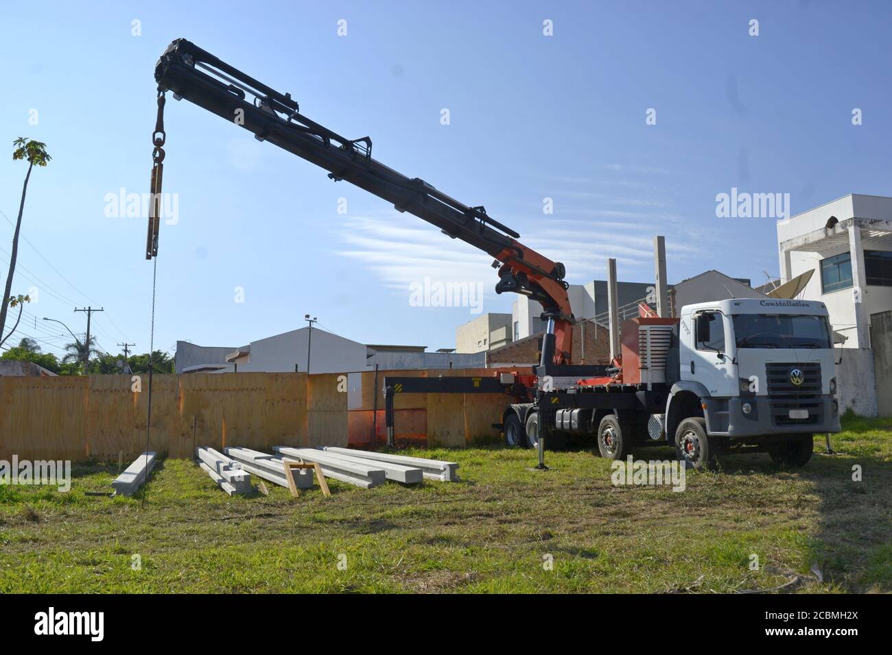 Lkw-Kran. Kranwagen im Tiefbau Betonträger heben in Brasilien, Südamerika in Panoramafoto im Vordergrund Betonbalken Stockfoto