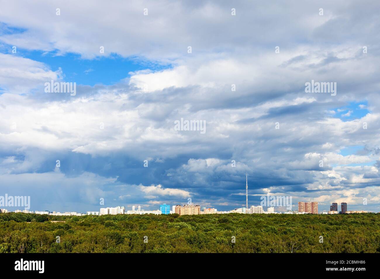Blauer wolkig Himmel über Wohngebieten und grünen Stadtpark In der Stadt am sonnigen Sommertag Stockfoto