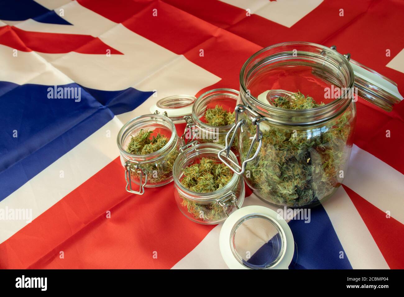 Große Menge an Cannabis Knospen. Marihuana Glas auf UK Flagge Stockfoto