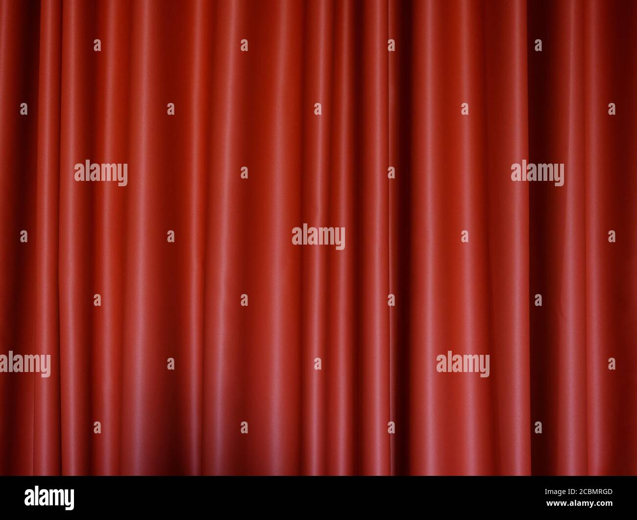 Vorderansicht eines gefalteten roten Polyestervorhangs. Hochauflösender texturierter Hintergrund im Vollformat. Stockfoto