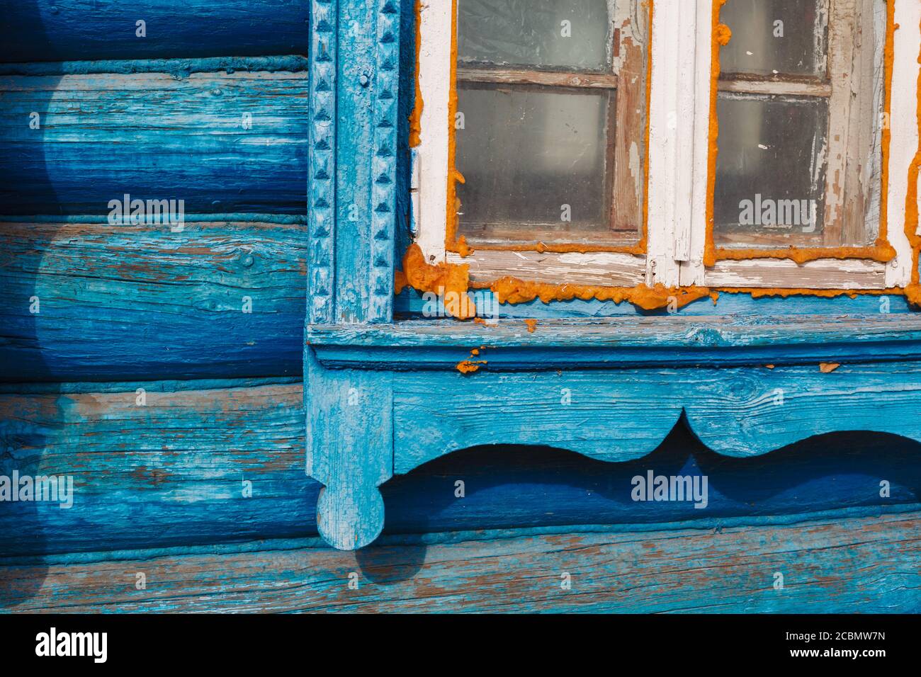Wry Holzrahmen auf einem Landhaus mit gelben Siegelschaum in russischen Dorf, DIY Fensterdichtung Stockfoto