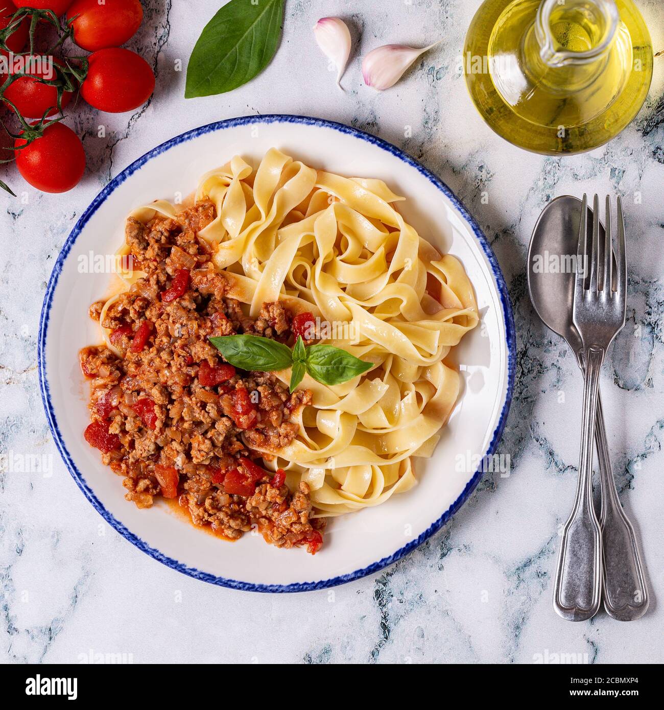 Traditionelle italienische Pasta Bolognese auf einem weißen Teller auf einem Marmorboden, Ansicht von oben. Stockfoto