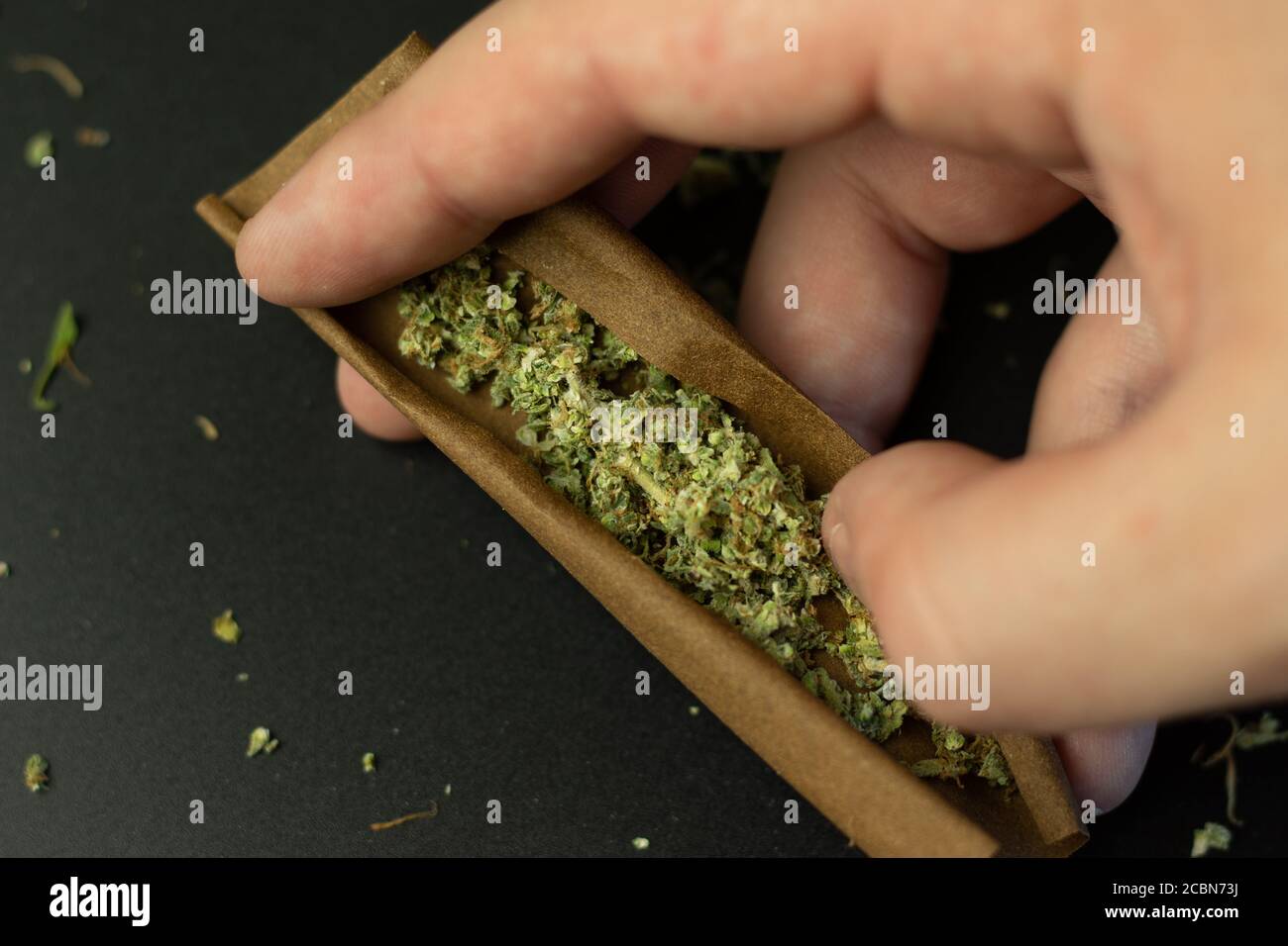 Man rollt Cananbis stumpf oder Joint close-up Draufsicht Stockfoto