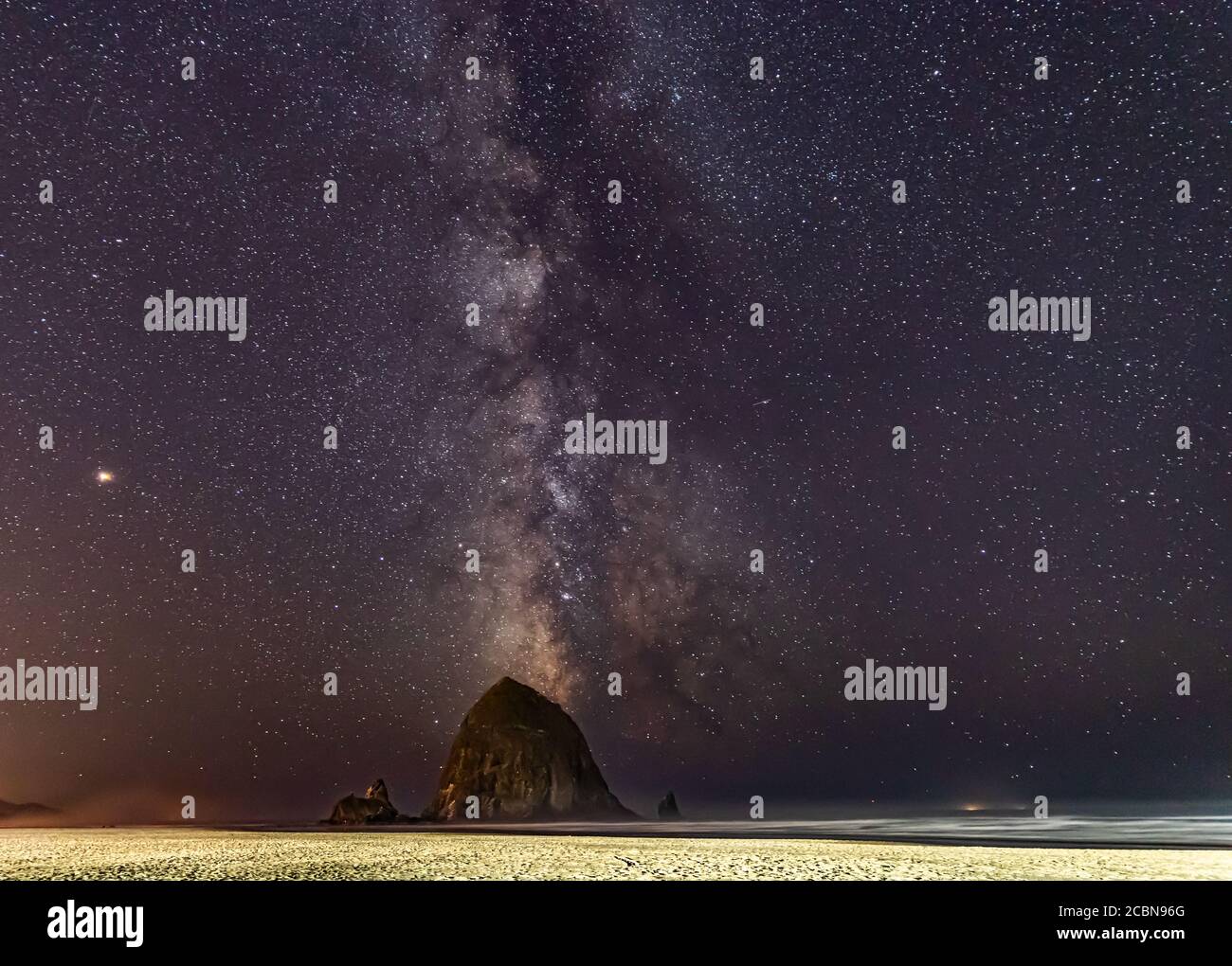 Milchstraße am Himmel über Haystack Rock auf Cannon Strand in Oregon Stockfoto