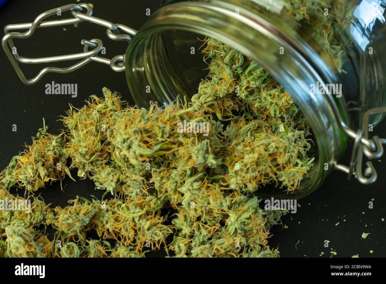 Cannabisknospen fallen aus dem Glas aus der Nähe Stockfoto