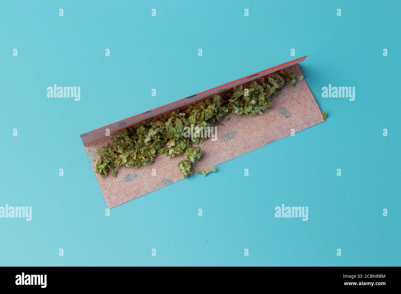 Cannabis in gemeinsamen Papier mit Fruchtgeschmack Draufsicht auf Blauer Hintergrund Stockfoto