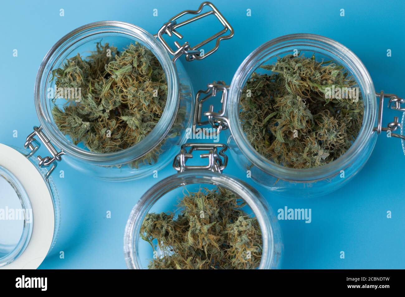 Glasgefäße mit medizinischen Marihuana Knospen Draufsicht auf blau Hintergrund Stockfoto