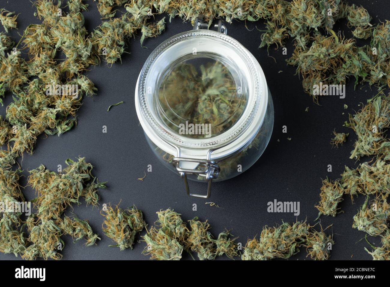 Glas mit Cannabis auf dem Hintergrund mit Marihuana Knospen Draufsicht. Unkraut Geschäftskonzept Stockfoto