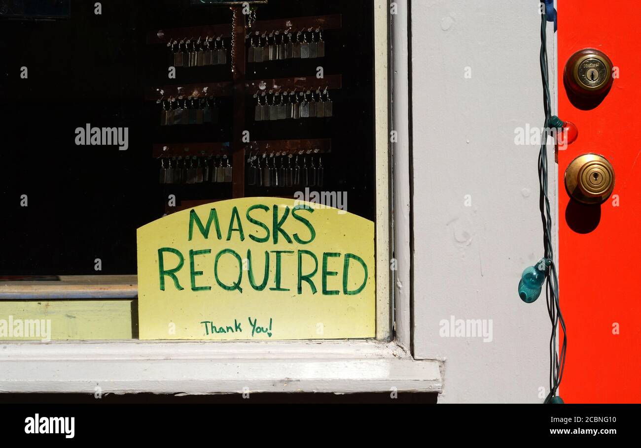 Ein Schild weist Kunden darauf hin, dass aufgrund der Pandemie von 2020 Gesichtsmasken im Inneren erforderlich sind. Stockfoto