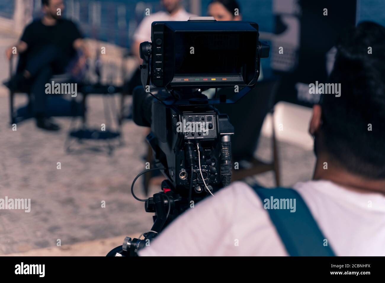 Hinter dem Szenenkonzept. Kameramann arbeitet an professionellen Kamera nehmen Film Interviewer Interview Berühmtheit Menschen machen Nachrichten im Freien. Stockfoto