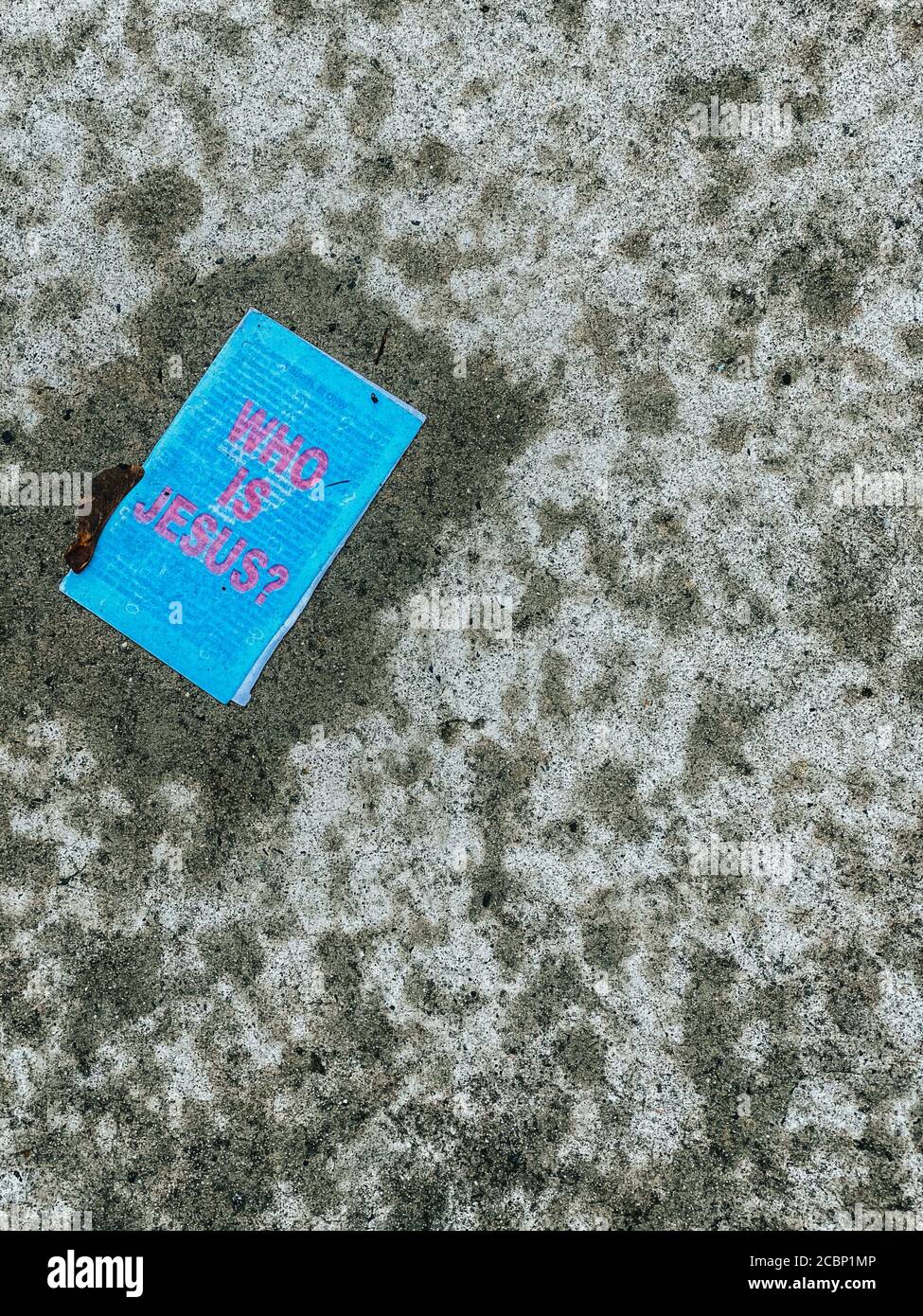 Ein nasses und blaues Stück Papier auf dem Boden Das sagt, wer ist Jesus in Pink Stockfoto