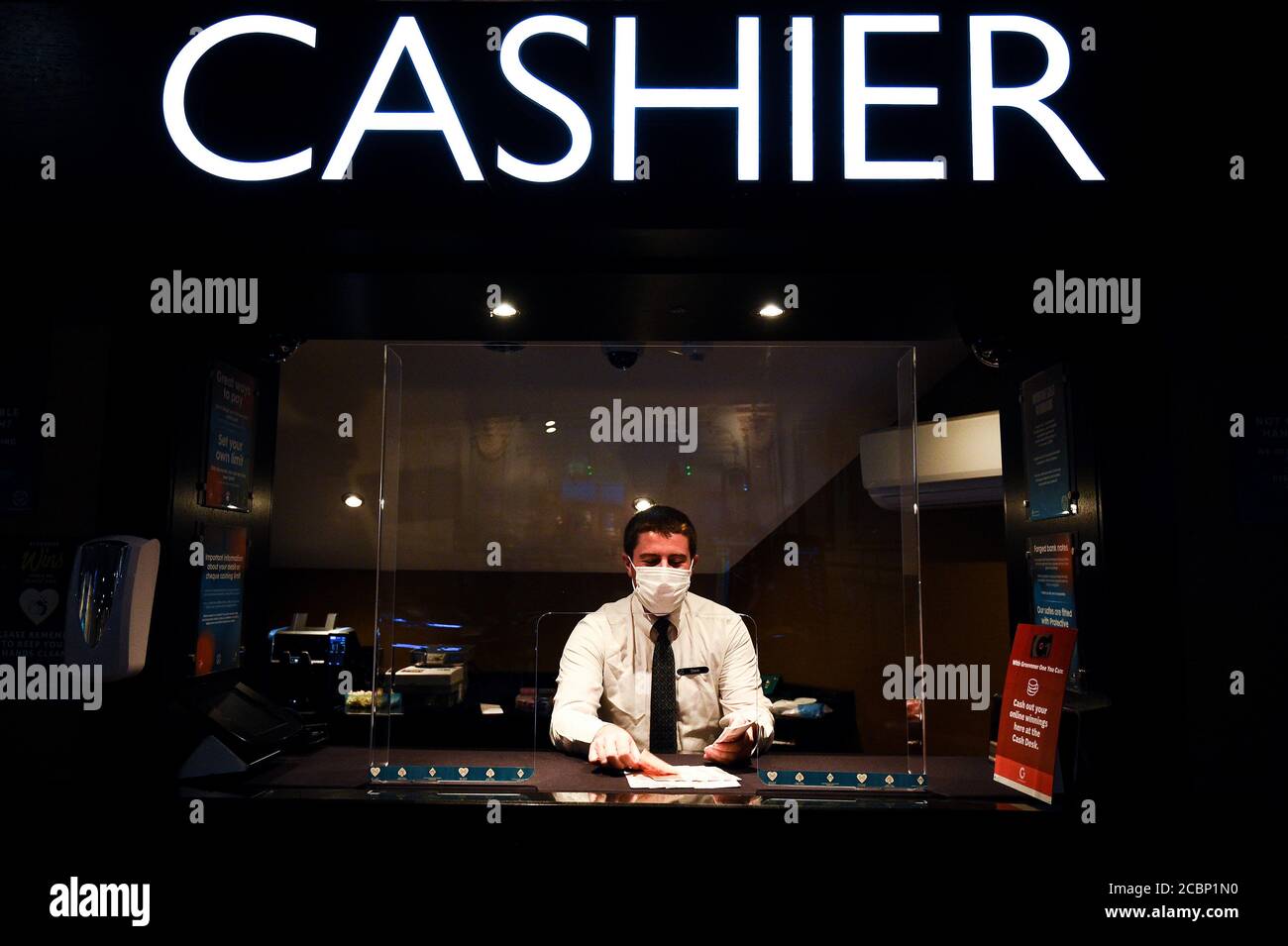 Ein Mitarbeiter mit PSA sortiert im Rialto Casino im Zentrum von London Geld, da er sich auf die Wiedereröffnung um Mitternacht vorbereitet, da die Maßnahmen zur Sperrung des Coronavirus in England weiter gelockert werden. Stockfoto